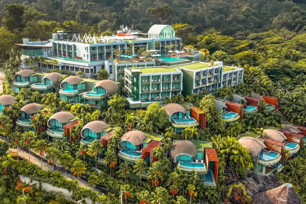 Aerial view of Crest Resort & Pool Villas on a green hillside above Patong, with private pool villas among tropical trees