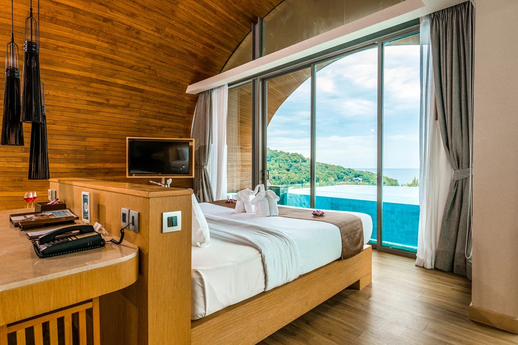 Premier Panorama Pool Villa bedroom at Crest Resort Phuket opening onto a private pool with hillside and sea views