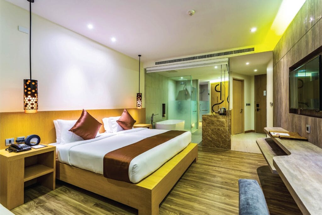 Deluxe room at Crest Resort Phuket with a king bed, freestanding bath and wooden floors